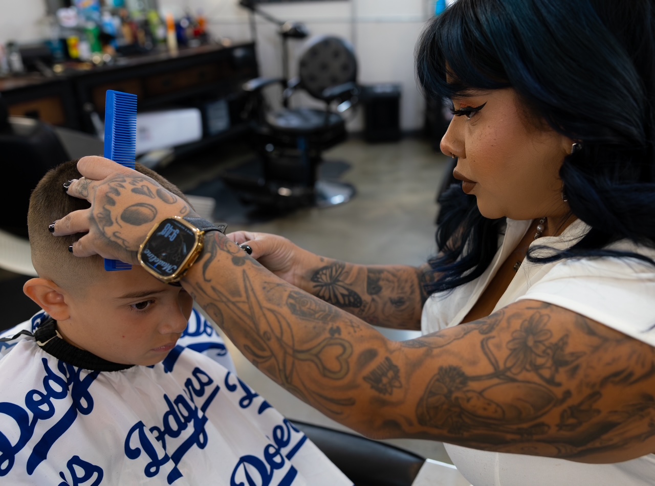 Madeline giving a young client a haircut at The Alley