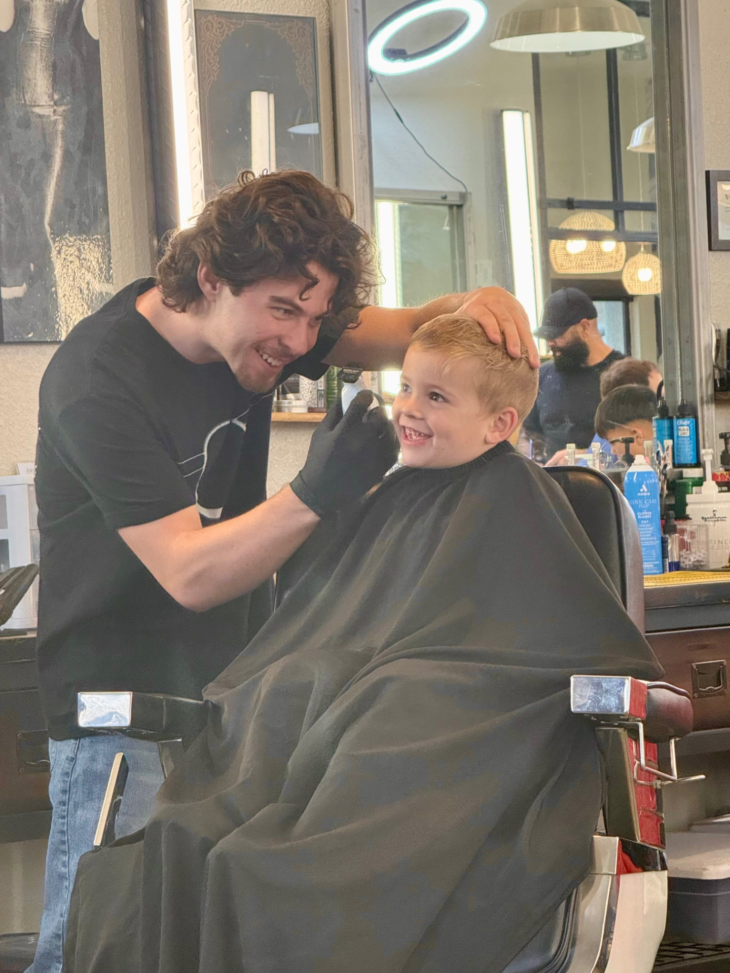 Kai giving a young client a haircut at The Alley